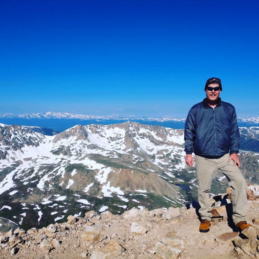 Martin Carney standing on top of a mountain in Colorado.