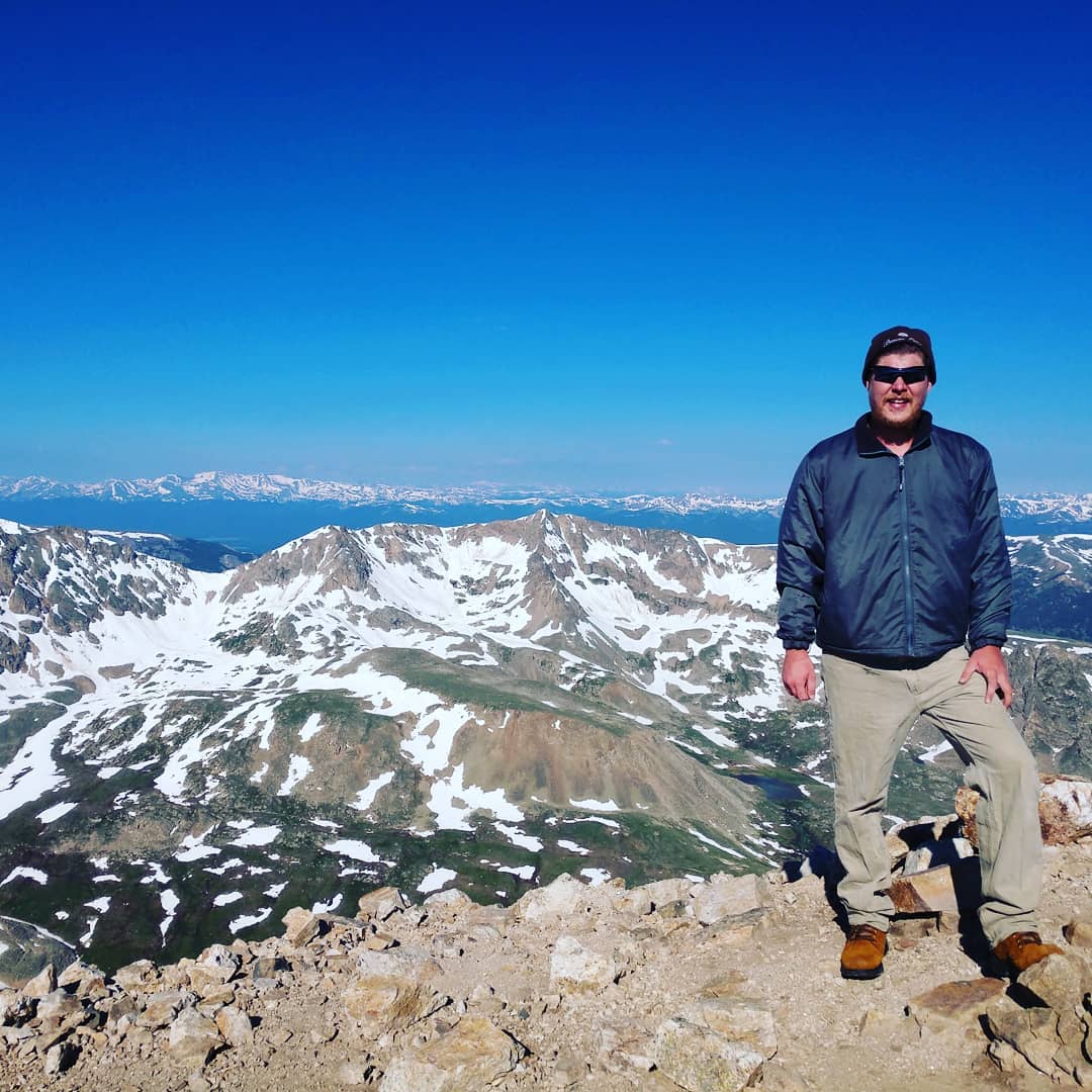 Martin Carney standing on top of a mountain in Colorado.