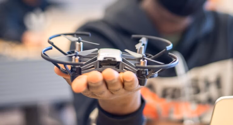 Close-up of a student holding a drone with the background blurred.