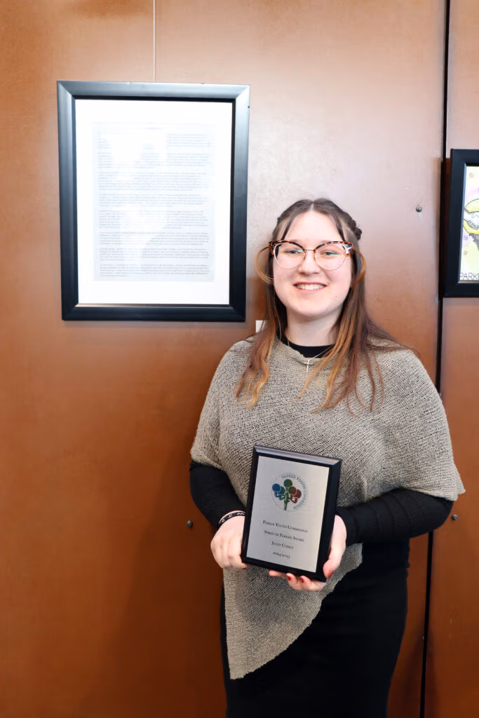  Jacey C. holding her Spirit of Parker award.