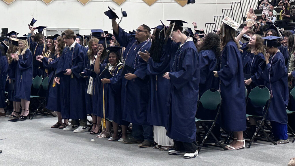CEC Colorado Springs students standing and throwing their caps in the air.