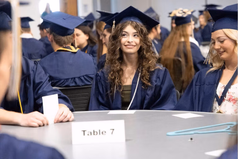 CEC Fort Collins High School graduates sitting in a group waiting for graduation to start.