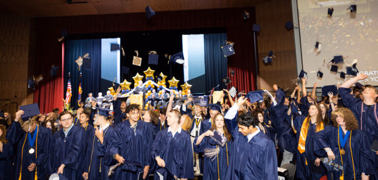 CECFC Graduating class of 2025 throwing their caps in the air.