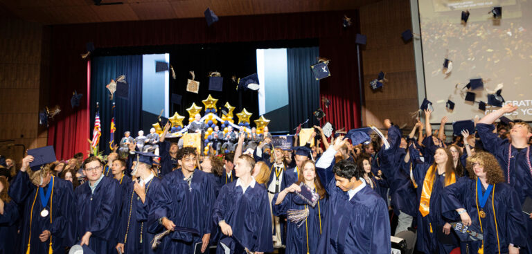 CECFC Graduating class of 2025 throwing their caps in the air.
