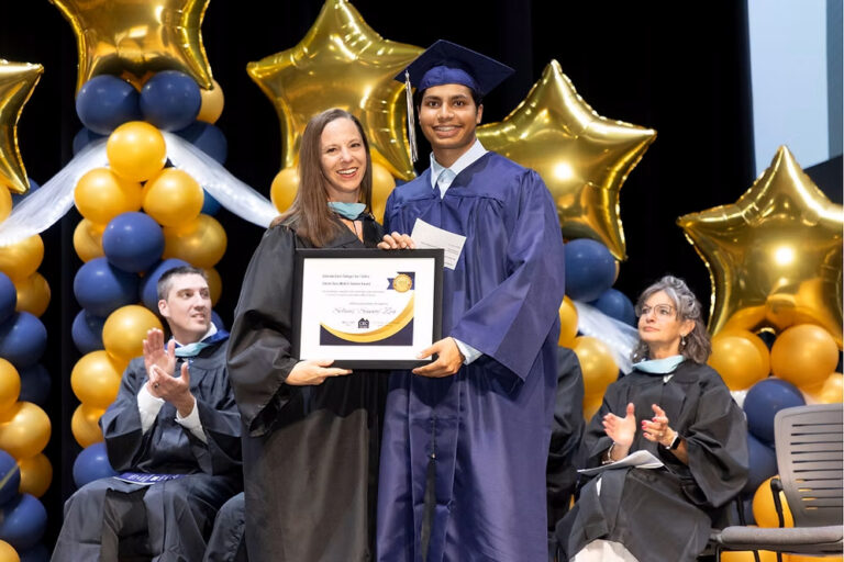 2025 CECFC Graduate receives an award on stage from Joliann Beck, Director of Academic & Career Advising.