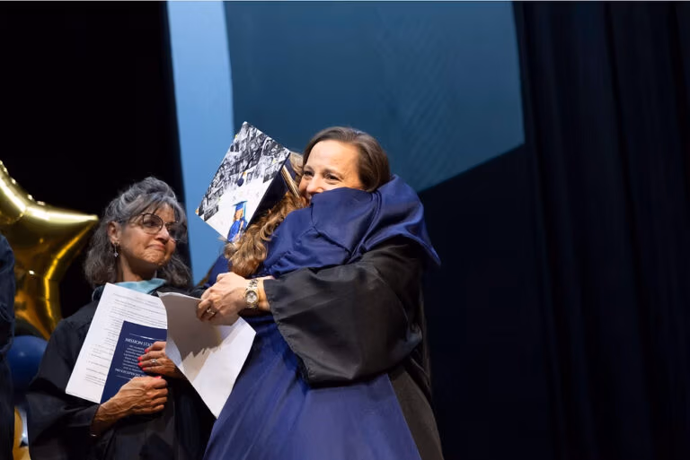 Larkyn Jones hugs Joliann Beck, Director of Academic & Career Advising at the 2025 CECFC graduation.