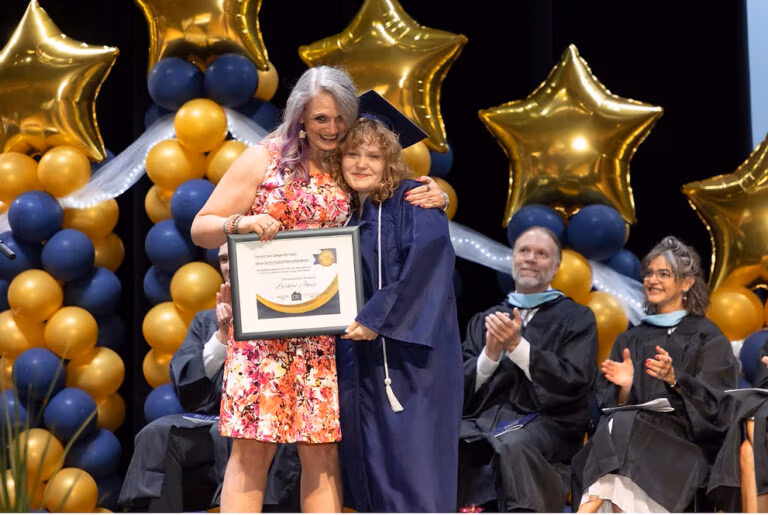 CEC Fort Collins graduate Larkyn Jones receives and award on stage during graduation.