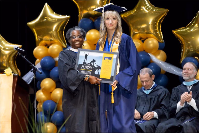 CEC Fort Collins graduate receives the Keith King award from Laura Calhoun, the President of the Governing Board.
