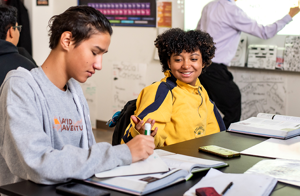 Two CECA high school students work together on a project in class.
