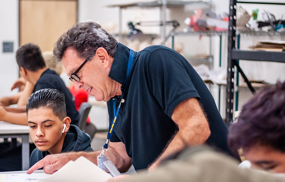 Colorado Early Colleges Aurora teacher helping a student in his class.