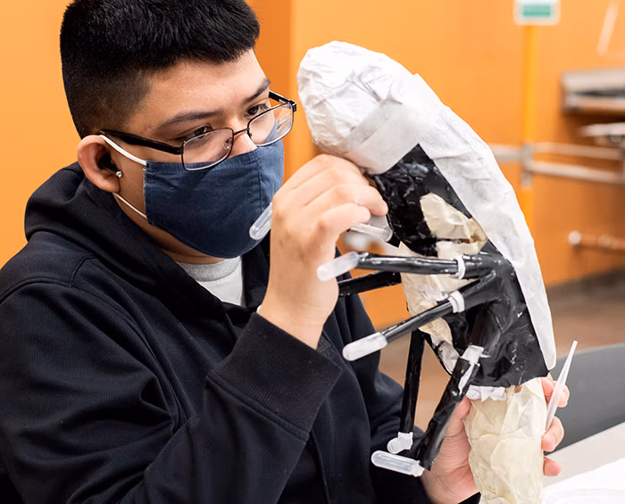 CEC Aurora student works on a sculpture at school.