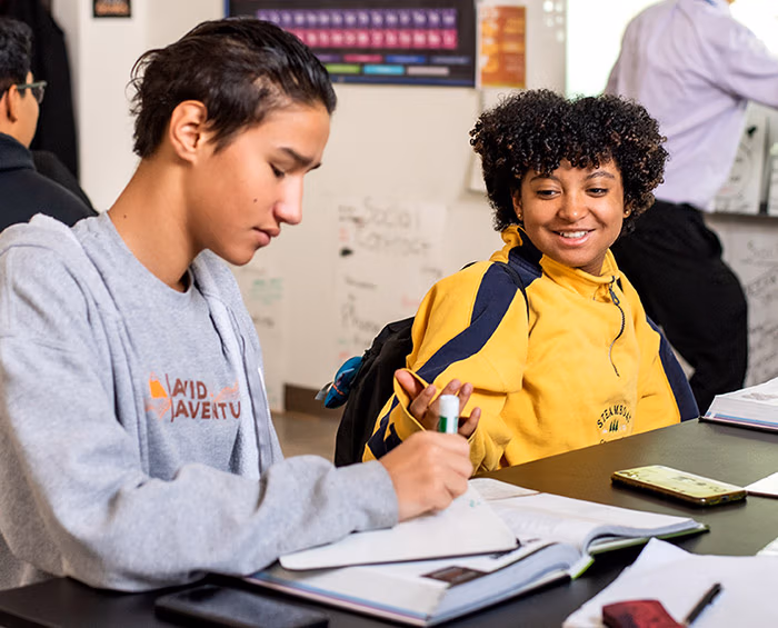 Two CECA high school students work together on a project in class.