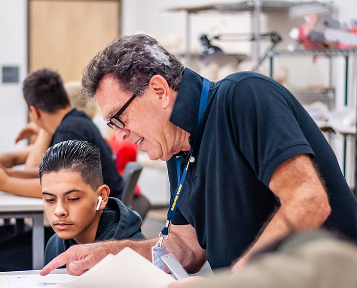 Colorado Early Colleges Aurora teacher helping a student in his class.