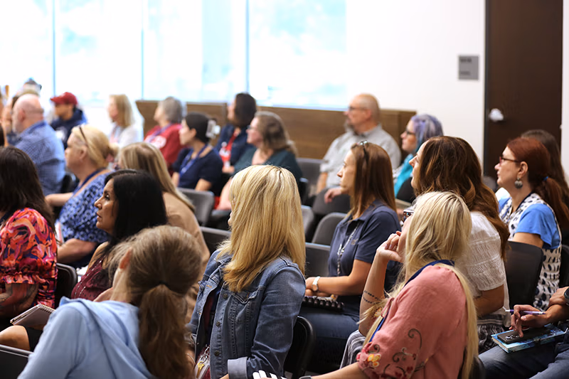 Group of people seated in a meeting room.