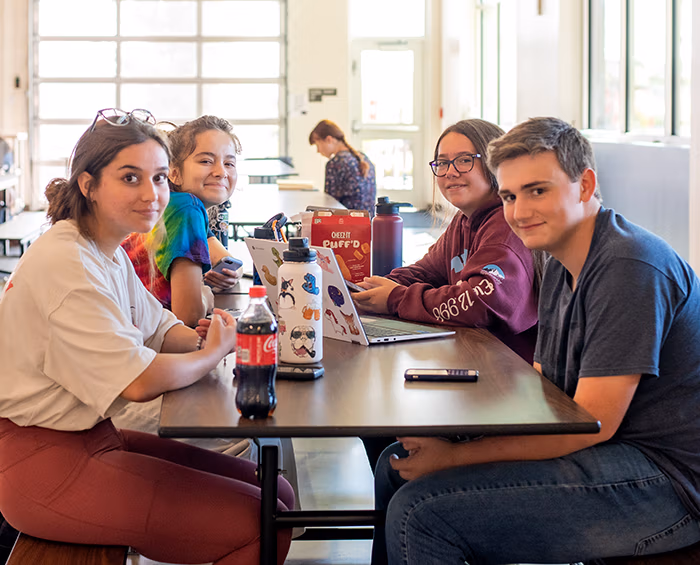 CECCR students sitting at a lunchroom table looking at the camera.