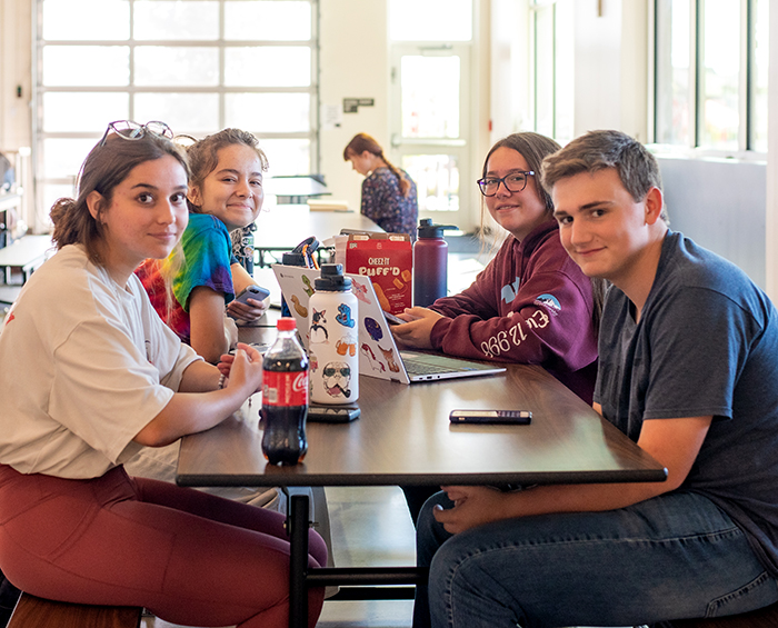 CECCR students sitting at a lunchroom table looking at the camera.