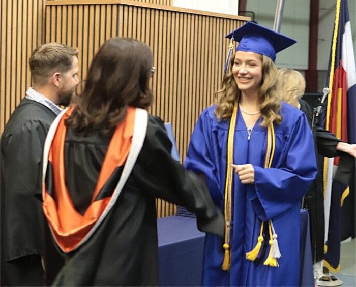 CECCR student receives her diploma and shakes the hand of CEC's CEO, Jill Gildea.