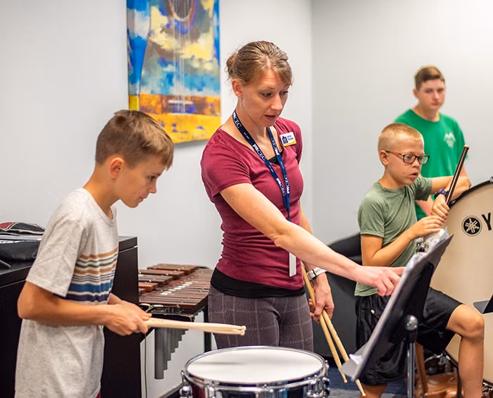 CECFC Middle School teacher instructs students on playing percussion in band class.