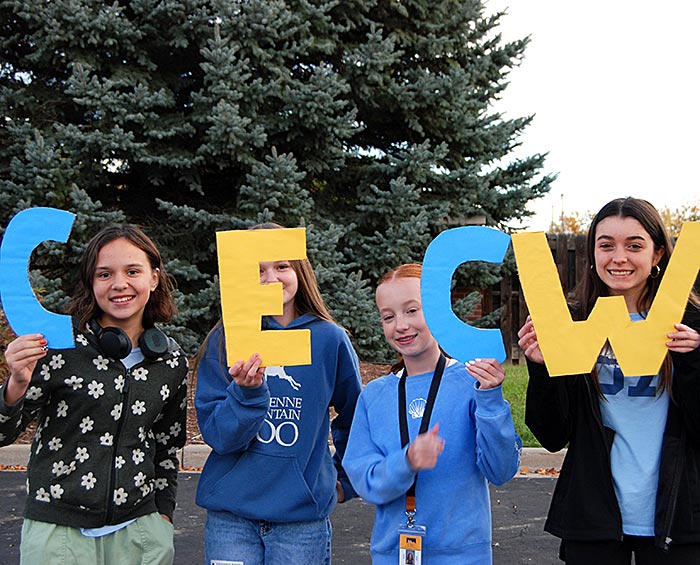 Four CEC Windsor students hold up the letters CECW.