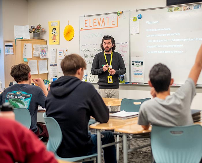 CECW Students in the foreground with a teacher in the background at the front of the classroom.