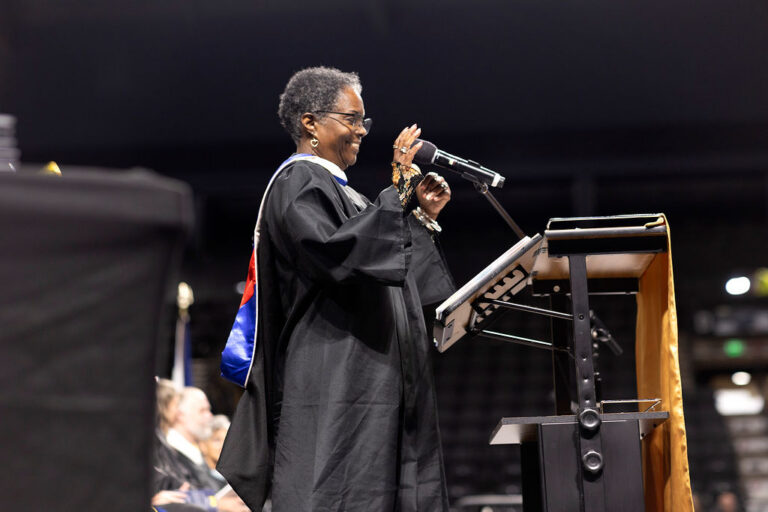 CEC Fort Collins High School Governing Board President, Laura Calhoun speaks onstage at graduation.