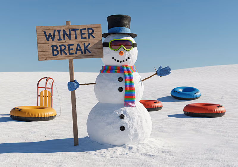 Snowman surrounded by snow and sleds holding a sign that says winter break.