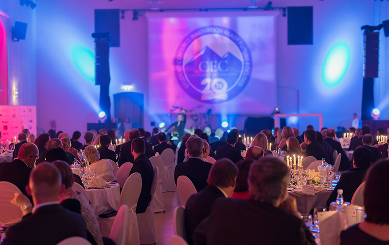 People dressed up looking at a stage for the 20th Anniversary Gala.