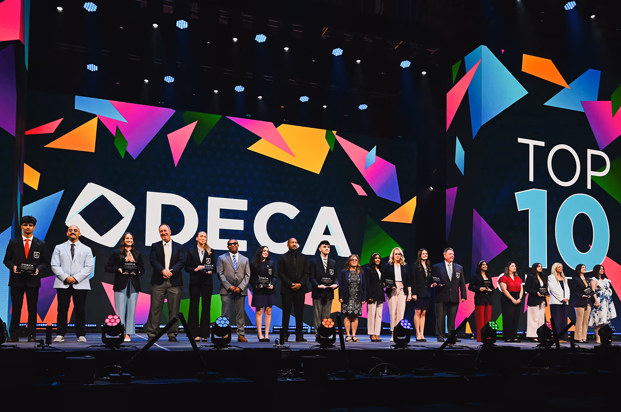 Students and teachers on stage at the 2026 DECA convention.